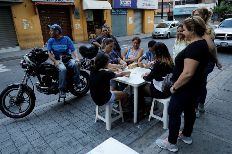 © Reuters. Resident play dominos on the street during a blackout in Caracas