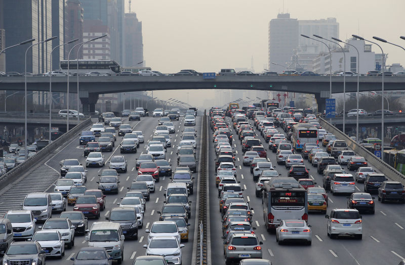 © Reuters. Cars drive on a main road through Beijing's central business area