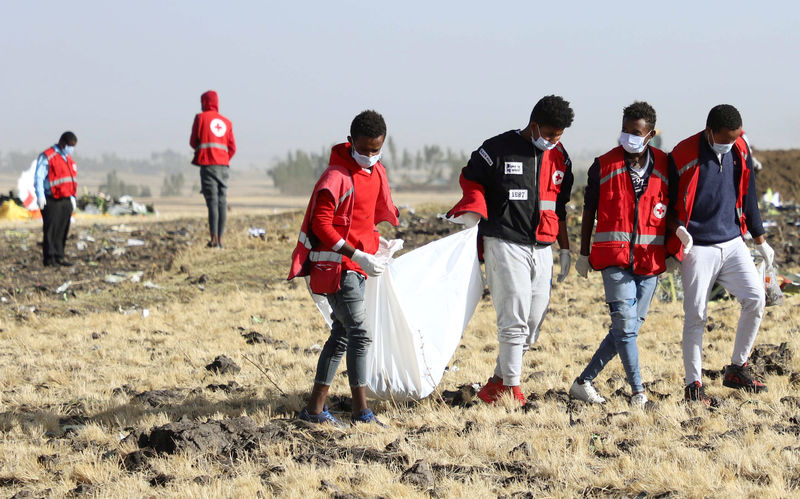 © Reuters. Members of the search and rescue team carry dismembered parts of passengers bodies at the scene of the Ethiopian Airlines Flight ET 302 plane crash, near the town of Bishoftu