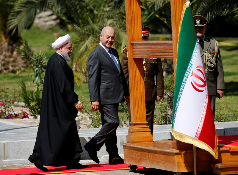 © Reuters. Iraq's President Barham Salih walks with Iranian President Hassan Rouhani during a welcome ceremony at Salam Palace in Baghdad