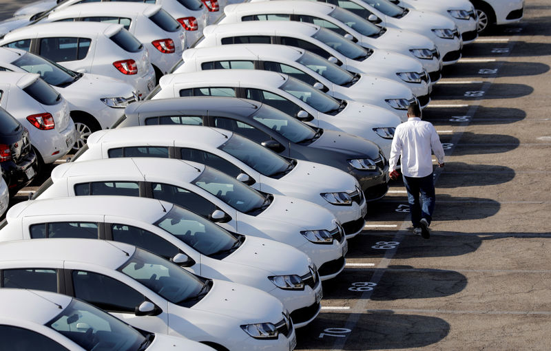 © Reuters. A person walks past cars at a parking lot in Sao Bernardo do Campo, Brazil