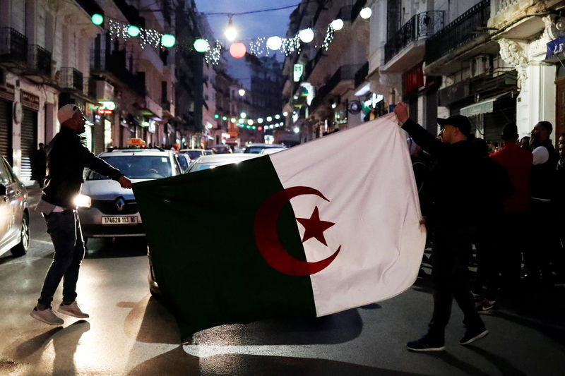 © Reuters. People celebrate on the streets after President Abdelaziz Bouteflika announced he will not run for a fifth term, in Algiers