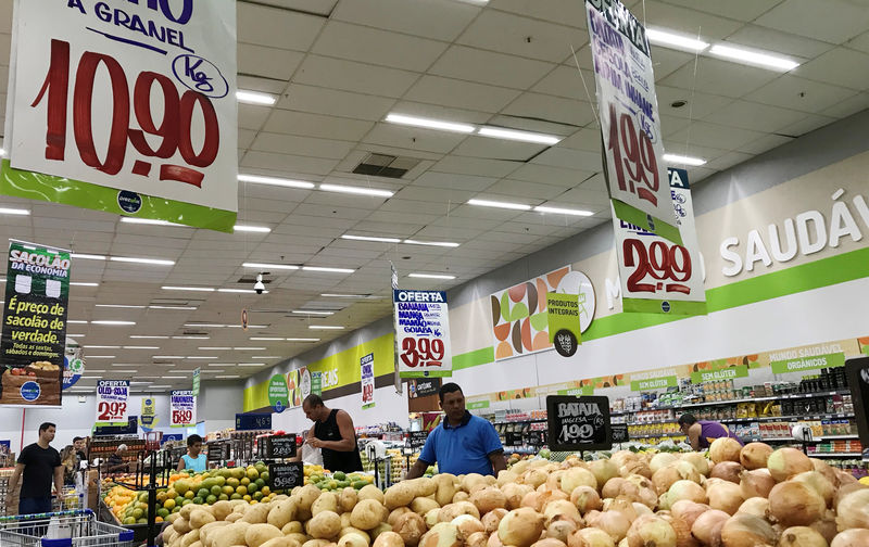 © Reuters. FILE PHOTO:  Customers look at the prices at a supermarket in Rio de Janeiro