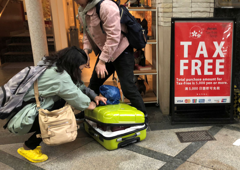 © Reuters. Shoppers from abroad fill their suitcase with Japanese cosmetics at a shopping district in Osaka