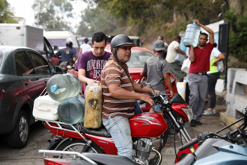 © Reuters. Un grupo de personas llevando agua en Caracas.