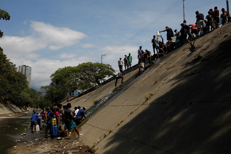 © Reuters. Foto del lunes de un grupo de personas recolectando agua en Caracas