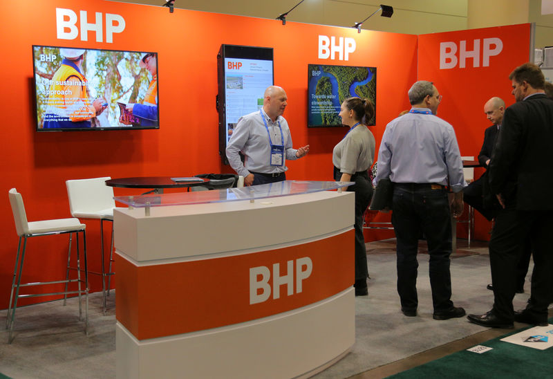 © Reuters. Visitors to the BHP booth speak with representatives during the PDAC convention in Toronto