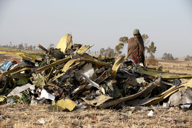 © Reuters. Ethiopian police officer walks past debris of the Ethiopian Airlines Flight ET 302 plane crash, near the town of Bishoftu, near Addis Ababa