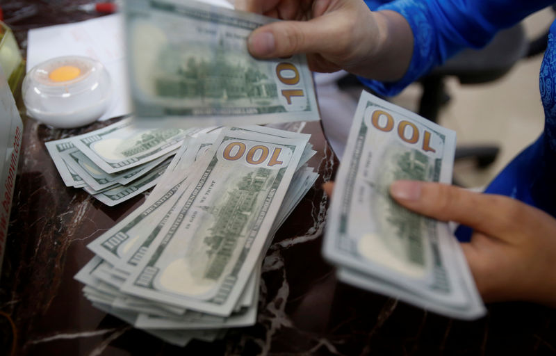 © Reuters. An employee of a bank counts US dollar notes at a branch in Hanoi