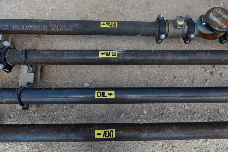 © Reuters. Pipes carry oil and water that has been separated at a production facility owned by Parsley Energy in the Permian Basin near Midland