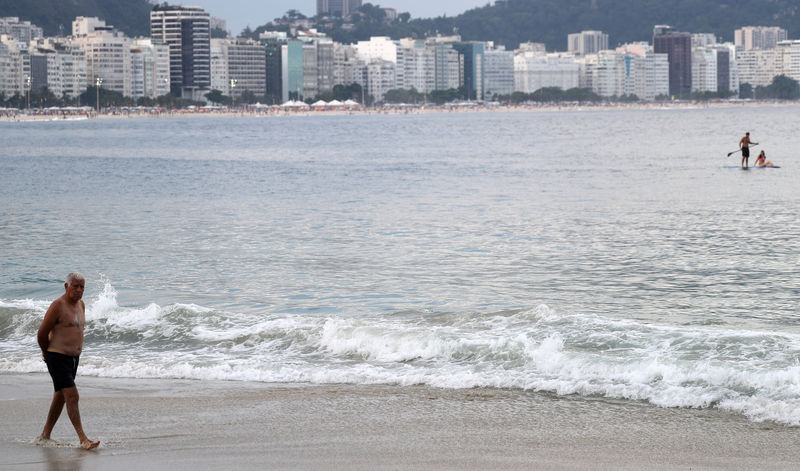 © Reuters. A senior citizen walks on Copacabana beach in Rio de Janeiro