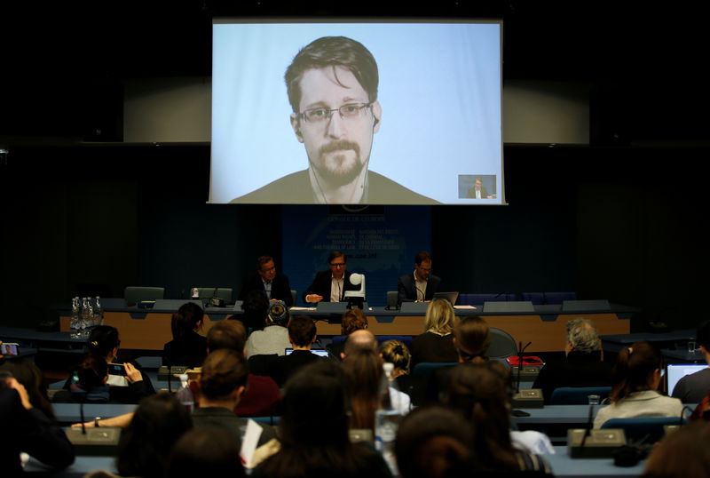 © Reuters. FILE PHOTO - Snowden speaks via video link as he takes part in a round table on the protection of whistleblowers at the Council of Europe in Strasbourg