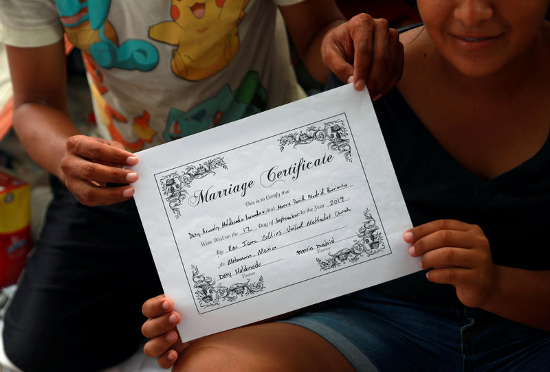 © Reuters. Honduran migrants Marvin Madrid and his new wife Dexy Maldonado show their "Marriage Certificate" during an interview with Reuters in an encampment in Matamoros