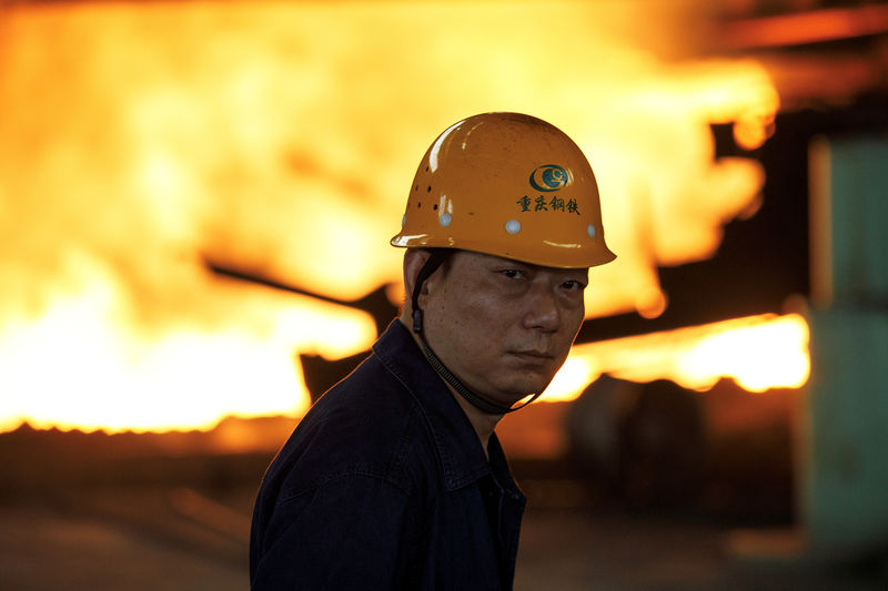 © Reuters. FILE PHOTO: Worker looks on in front of a blast furnace at the Chongqing Iron and Steel plant in Changshou