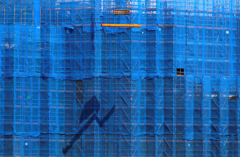 © Reuters. FILE PHOTO: A crane lifts building materials in front of scaffolding at a construction site in central Sydney