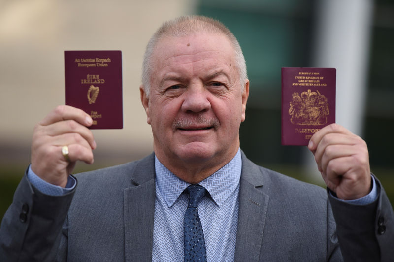 © Reuters. FILE PHOTO: Raymond McCord displays his Irish and United Kingdon passports to media in Belfast, Northern Ireland