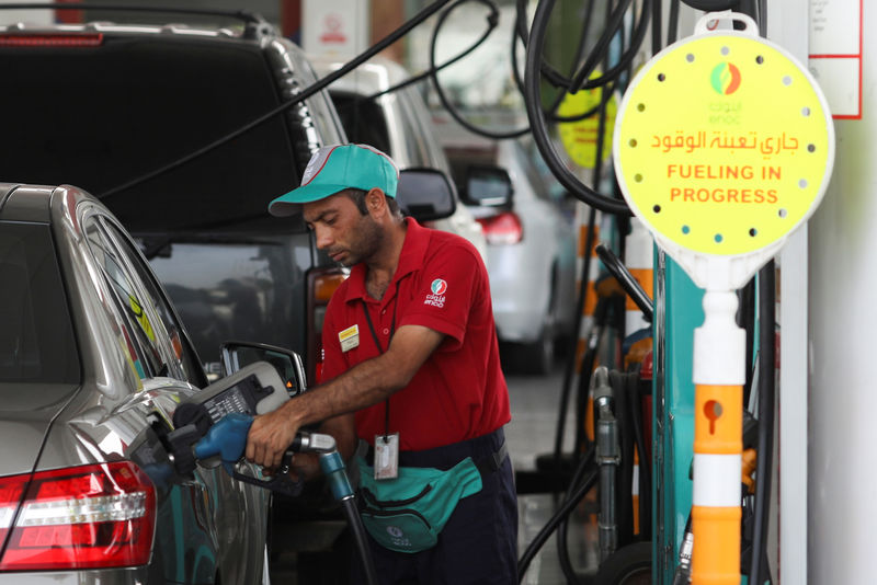© Reuters. A worker fills a vehcile with petrol at a gas station in Dubai
