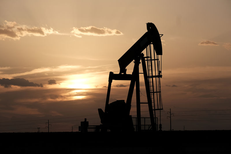 © Reuters. Oil pump jacks work at sunset near Midland