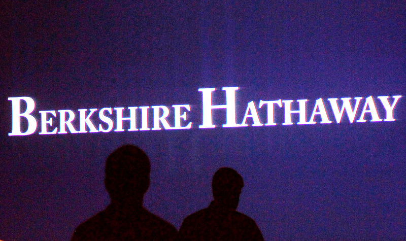 © Reuters. FILE PHOTO: File photo of Berkshire Hathaway shareholders walking by a video screen at the company's annual meeting in Omaha