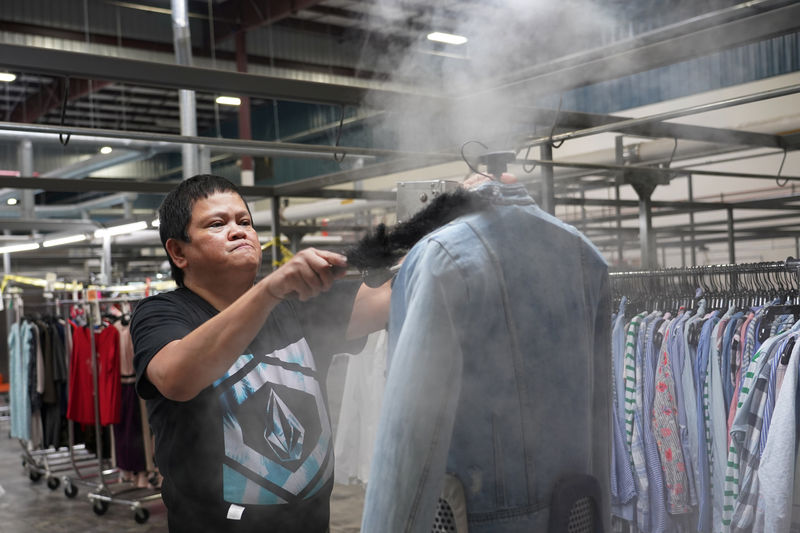 © Reuters. Yolanda Malolos steams a jacket at subscription clothing rental company Le Tote's warehouse in Stockton
