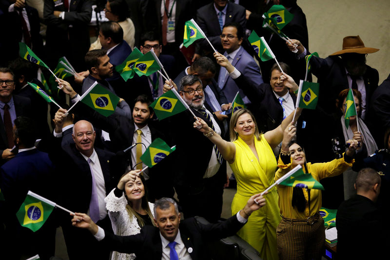 © Reuters. FILE PHOTO: Members of congress and supporters of the pension reform bill react during a session to vote the pension reform bill at plenary of the Chamber of Deputies in Brasilia