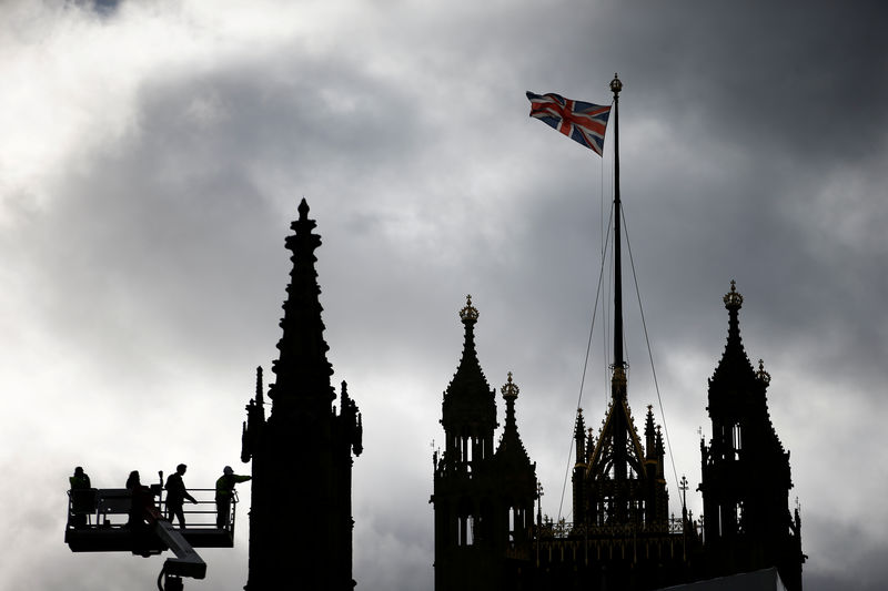 © Reuters. FILE PHOTO: Workers using a crane can be seen inspecting part of the roof of the Houses of Parliament in London
