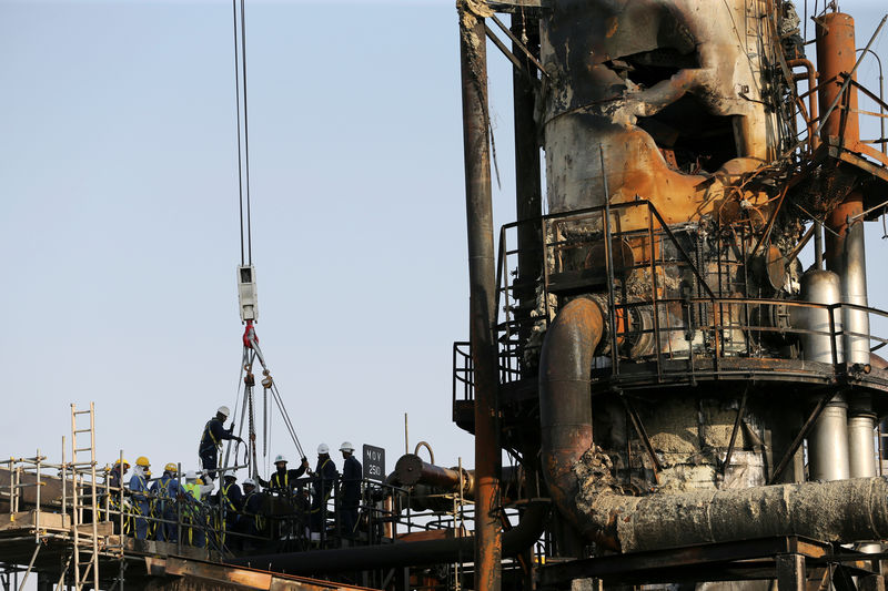 © Reuters. FILE PHOTO: Workers are seen at the damaged site of Saudi Aramco oil facility in Abqaiq