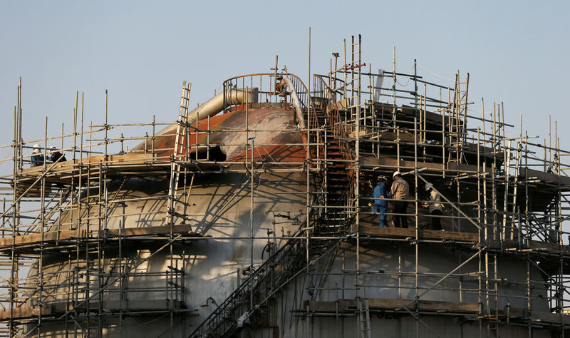 © Reuters. FILE PHOTO: Workers are seen at the damaged site of Saudi Aramco oil facility in Abqaiq