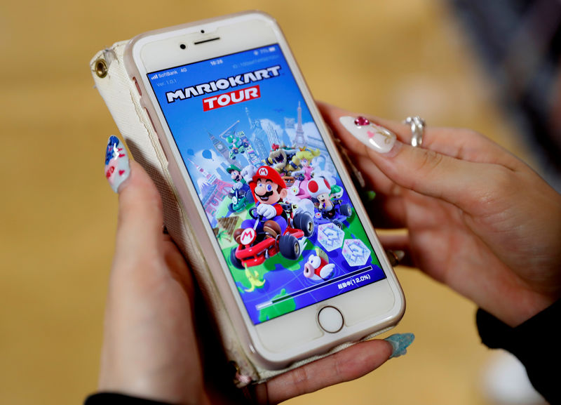 © Reuters. A woman shows the mobile title Mario Kart Tour on her smartphone during an interview with Reuters at Tatio's game center in Tokyo