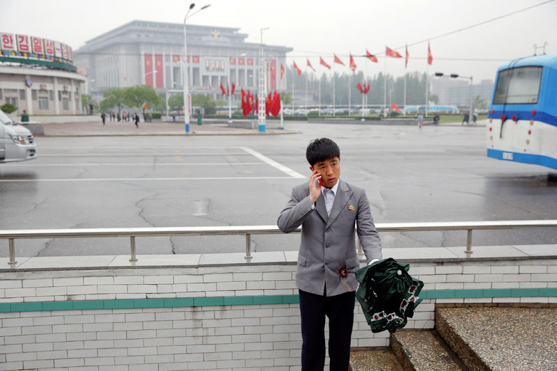 © Reuters. FILE PHOTO : A man speaks on the phone in front of the April 25 House of Culture, venue of the Workers' Party of Korea (WPK) congress in Pyongyang, North Korea