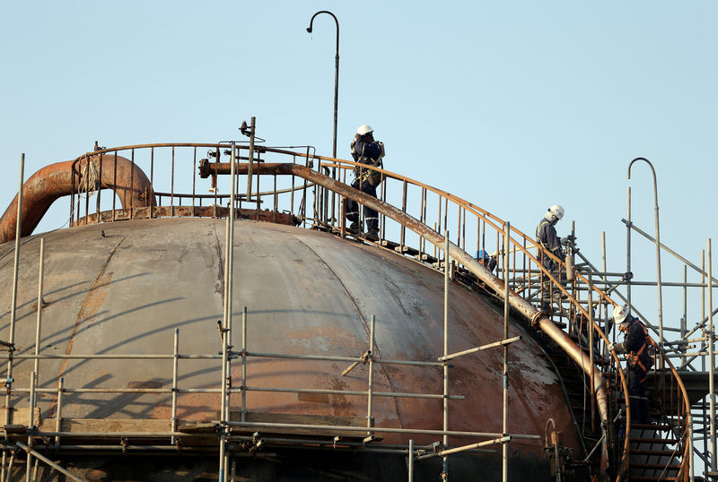 © Reuters. FILE PHOTO: Workers are seen at the damaged site of Saudi Aramco oil facility in Abqaiq