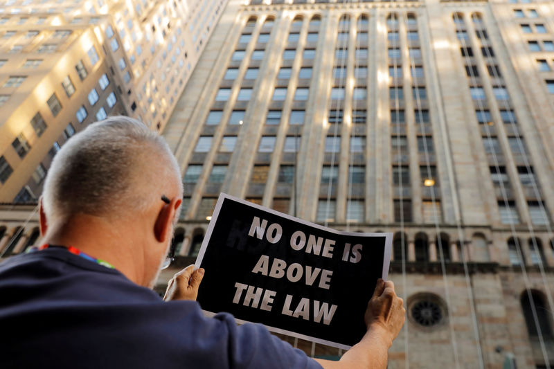 © Reuters. Demonstrators hold protest signs as part of a demonstration in support of impeachment hearings in New York