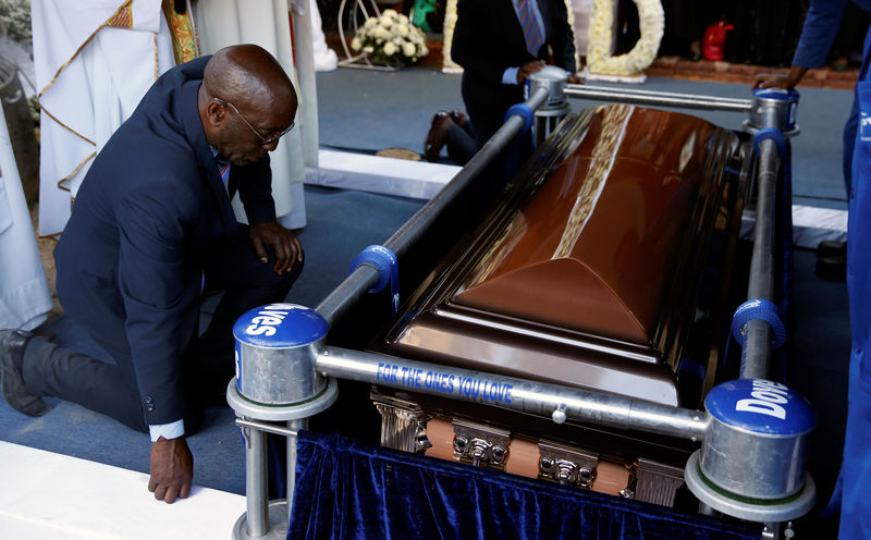 © Reuters. Mourners gather beside the coffin of former Zimbabwean President Robert Mugabe at his burial site  in Kutama, Zimbabwe