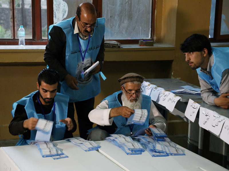 © Reuters. Trabajadores de la comisión electoral afgana cuentan papeletas en los comicios presidenciales, en Kabul.