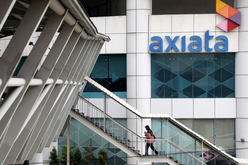 © Reuters. A woman walks past the Axiata headquarters building in Kuala Lumpur