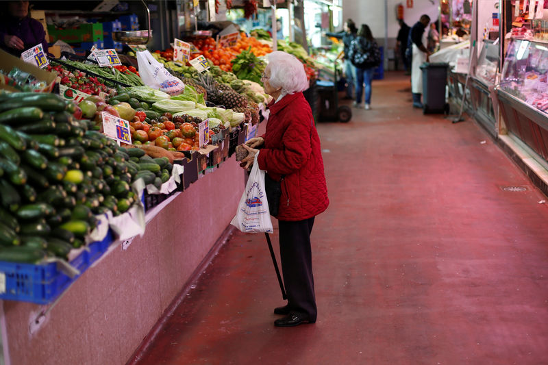 © Reuters. FOTO DE ARCHIVO: Una mujer mira frutas y verduras en un puesto de mercado en Madrid.