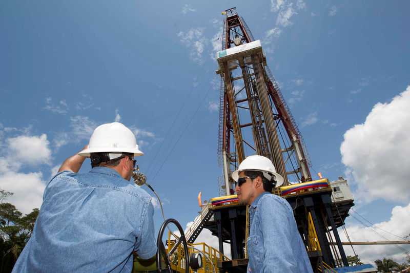 © Reuters. FILE PHOTO: Workers stand near an oil drilling rig belonging to Petroamazonas at Miranda Port in Tiputini