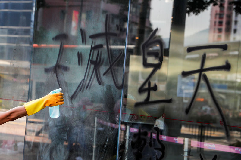 © Reuters. A worker cleans graffiti off the vandalized exterior of a Bank of China branch in Tsuen Wan, Hong Kong
