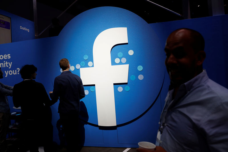 © Reuters. Attendees walk past a Facebook logo during Facebook Inc's F8 developers conference in San Jose