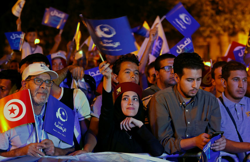 © Reuters. Supporters of Tunisia's moderate Islamist Ennahda party carry flags during campaign event in Tunis