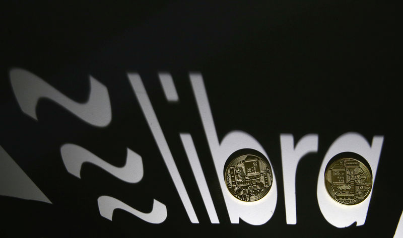 © Reuters. FILE PHOTO: Shadow of a 3D-printed Facebook Libra cryptocurrency logo is seen near cryptocurrency representation in this illustration taken