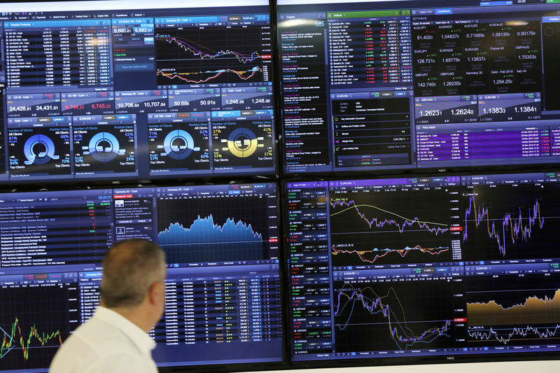 © Reuters. A trader works as a screen shows market data behind him in London