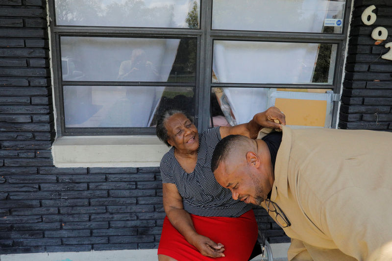 © Reuters. Mary Tyson, the mother of Pastor Clifford Tyson, adjusts his shirt collar outside her home in Tampa