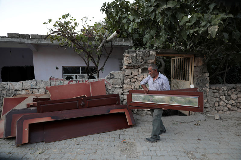 © Reuters. Cemil Yavanas, a resident of Hasankeyf, which will be significantly submerged by the Ilisu Dam, carries old furniture from his house before moving to new Hasankeyf