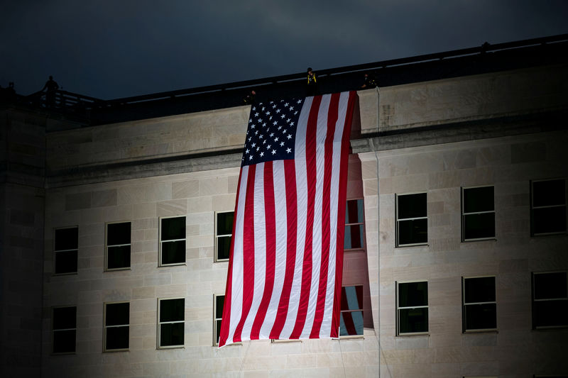 © Reuters. FILE PHOTO:  The U.S. flag is unfurled at sunrise as part of the 18th annual September 11 observance ceremony at the Pentagon