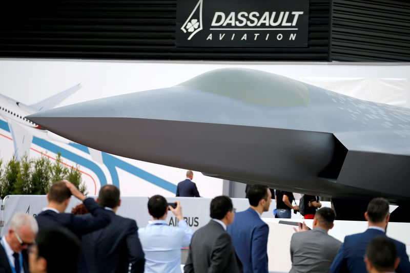 © Reuters. FILE PHOTO: Visitors look at the French-German-Spanish New Generation Fighter (NGF) model during the 53rd International Paris Air Show at Le Bourget Airport near Paris
