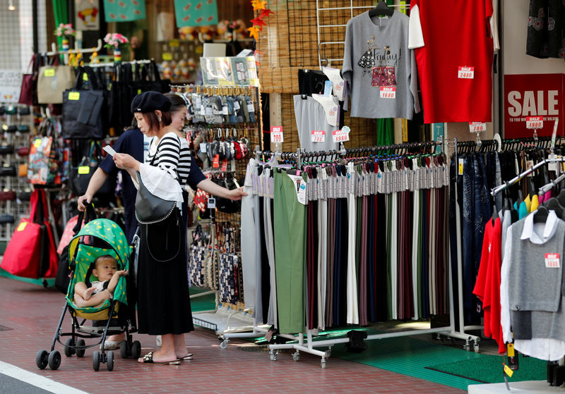 © Reuters. FILE PHOTO: Shoppers look around goods at a shop in Tokyo
