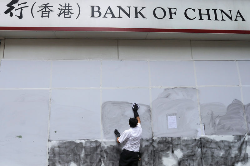 © Reuters. FOTO DE ARCHIVO. Un trabajador limpia un grafiti en una sucursal del Bank of China en Hong Kong. Octubre 2019. REUTERS/Susana Vera
