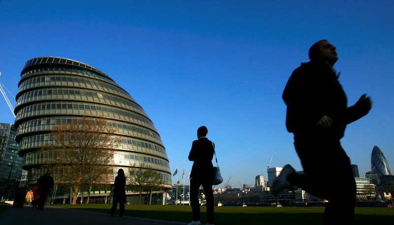 © Reuters. FILE PHOTO: People walk past City Hall in London