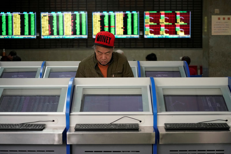 © Reuters. An investor looks at computer screens showing stock information at a brokerage house in Shanghai